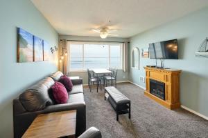 a living room with a couch and a television and a table at Sea Gypsy Rentals in Lincoln City +22 photos