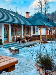 a building with a blue roof in the snow at Sadova Village-Casa Elena in Sadova