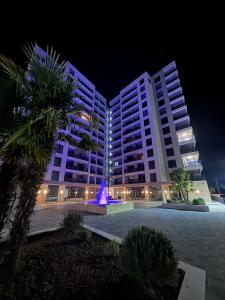 a large building with a fountain in front of it at night at Moderan 80m2 apartman - 2 kupatila - terasa - blizu centra i plaze in Bar