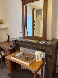 a table with a mirror on top of a fireplace at Maison Dentelle in Caudry