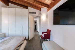 a bedroom with white cabinets and a bed and a chair at Terrazzo apartment in Bellagio