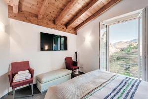 a bedroom with a bed and a chair and a window at Terrazzo apartment in Bellagio