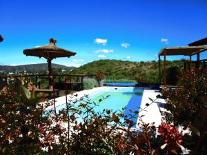 a large swimming pool with an umbrella at Torii Cabañas de Montaña in Villa Carlos Paz
