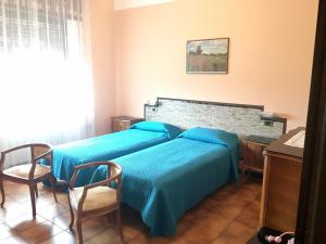 カプリーノ・ヴェロネーゼにあるCasa Annaのベッドルーム1室(青いシーツが備わるベッド2台付)