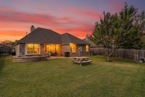 a house with a picnic table in the yard at 8min Texas A&M 1 King Beds firepit GriddleGrill in College Station