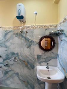 a bathroom with a sink and a mirror at Hotel Raj in mayapur +26 photos