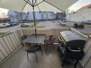 a table and chairs on a balcony with an umbrella at TechisFerienWohnung in Magdeburg
