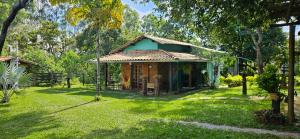 a small house in a yard with a green lawn at Sítio Roda d'Água in Lagoa Santa