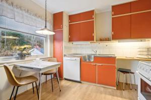 a kitchen with orange cabinets and a table and chairs at Alam,s Villa in Kabelvåg