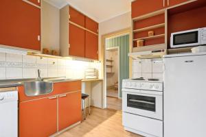 a kitchen with orange cabinets and white appliances at Alam,s Villa in Kabelvåg +13 photos