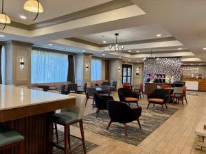 a lobby of a hotel with chairs and a bar at Hampton Inn McHenry in McHenry