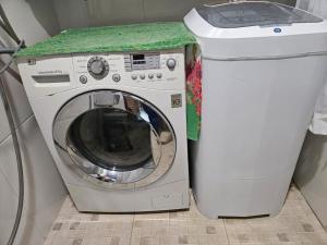 a washing machine with a green counter next to a trash can at Chacara pais e filhas in Socorro