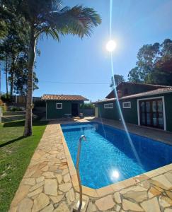 a swimming pool with a fountain in a yard at Chacara pais e filhas in Socorro