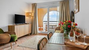 a living room with a dining room table with a television at Casa Bellevue in Beausoleil