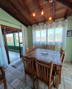 a dining room with a wooden table and chairs at Chacara pais e filhas in Socorro