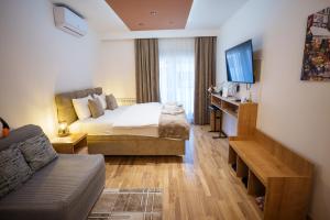 a hotel room with a bed and a couch at Studio DORA SS in Stari Banovci