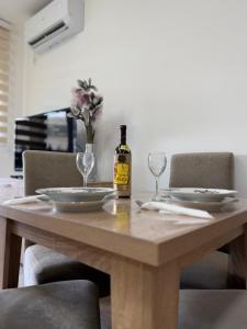 a bottle of wine sitting on a wooden table with glasses at Apartman Kitanović 1 Vrnjačka Banja in Ruđinci