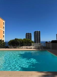 a blue swimming pool with buildings in the background at Casa Bellevue in Beausoleil