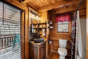 a bathroom with a toilet in a wooden cabin at Beary Cozy Cabin by Venture Smoky Mountains in Sevierville +57 photos