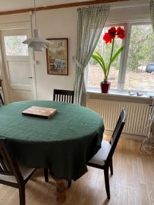 ein Esszimmer mit einem grünen Tisch und einem Fenster in der Unterkunft Kalvsvik in Värmdö