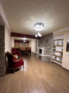 a living room with a fireplace and a table and chairs at Fireside Fiesta Haven in Maglaki