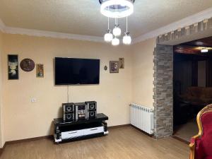 a living room with a flat screen tv on the wall at Fireside Fiesta Haven in Maglaki