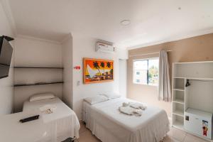 a bedroom with two beds and a window at Pousada La Belle in Maragogi