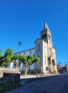 a church with a tower with a tree in front of it at Casa de sney in Sarria