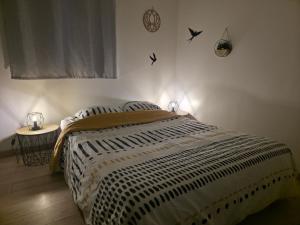 a bedroom with a bed and a table with birds on the wall at Studio cosy - Jacuzzi inclus - À 5 min du Mans in Mulsanne