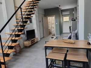 a staircase in a living room with a table and a dining room at Konstantinos Loft in Serres