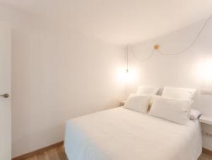 a white bed with white pillows in a bedroom at 1 BR Condo Chapelas Costa del Silencio AC Pool WIFI in Arona +36 photos