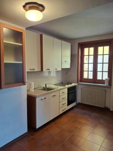 a kitchen with white cabinets and a white refrigerator at La ca' dal Tunec in Valduggia
