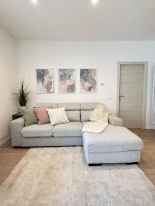 a living room with a gray couch and a rug at Al Nio in Baselga di Pinè