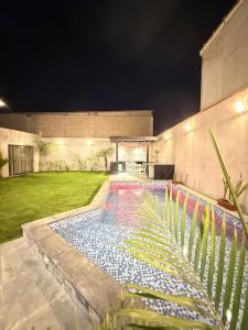 a swimming pool in the middle of a yard at night at Pool house, garden, grill in Ica