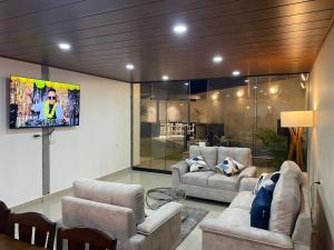 a living room with couches and a flat screen tv at Pool house, garden, grill in Ica