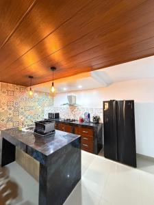a kitchen with black appliances and a wooden ceiling at Pool house, garden, grill in Ica