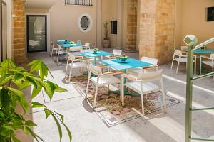 een rij blauwe tafels en stoelen op een patio bij Hotel San Michele in Trapani