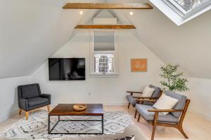 a living room with two chairs and a tv at Steps to NYC Train! Charming Carriage House Loft in Glen Ridge