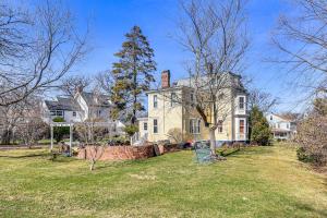 a large white house with a tree in the yard at Steps to NYC Train! Charming Carriage House Loft in Glen Ridge