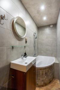 a bathroom with a sink and a bath tub at Apartamenty Sawino 4 in Tykocin +41 photos