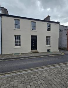 a white building with a black door on a street at AbbeyLane house in Trim