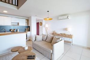a living room with a couch and a kitchen at Appartement Reflets Marins in Saint Martin