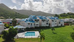 a row of houses with a pool and mountains in the background at Appartement Reflets Marins in Saint Martin