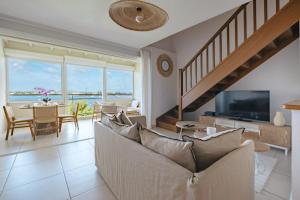 a living room with a couch and a television at Appartement Reflets Marins in Saint Martin
