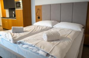 a large bed with white sheets and pillows on it at Liptov Hills in Liptovský Mikuláš