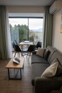 a living room with a couch and chairs and a large window at Liptov Hills in Liptovský Mikuláš