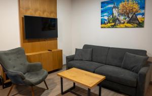 a living room with a couch and a tv at Liptov Hills in Liptovský Mikuláš
