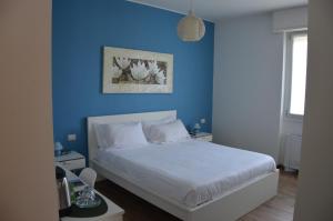 a bedroom with a blue wall and a white bed at BLUE Airuno in Airuno