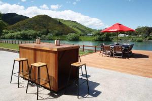 a wooden deck with a table and chairs and an umbrella at Mata-au Lodge in Beaumont
