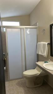 a bathroom with a shower and a toilet and a sink at Hotel El Rancho in San Juan Bautista Tuxtepec +17 photos